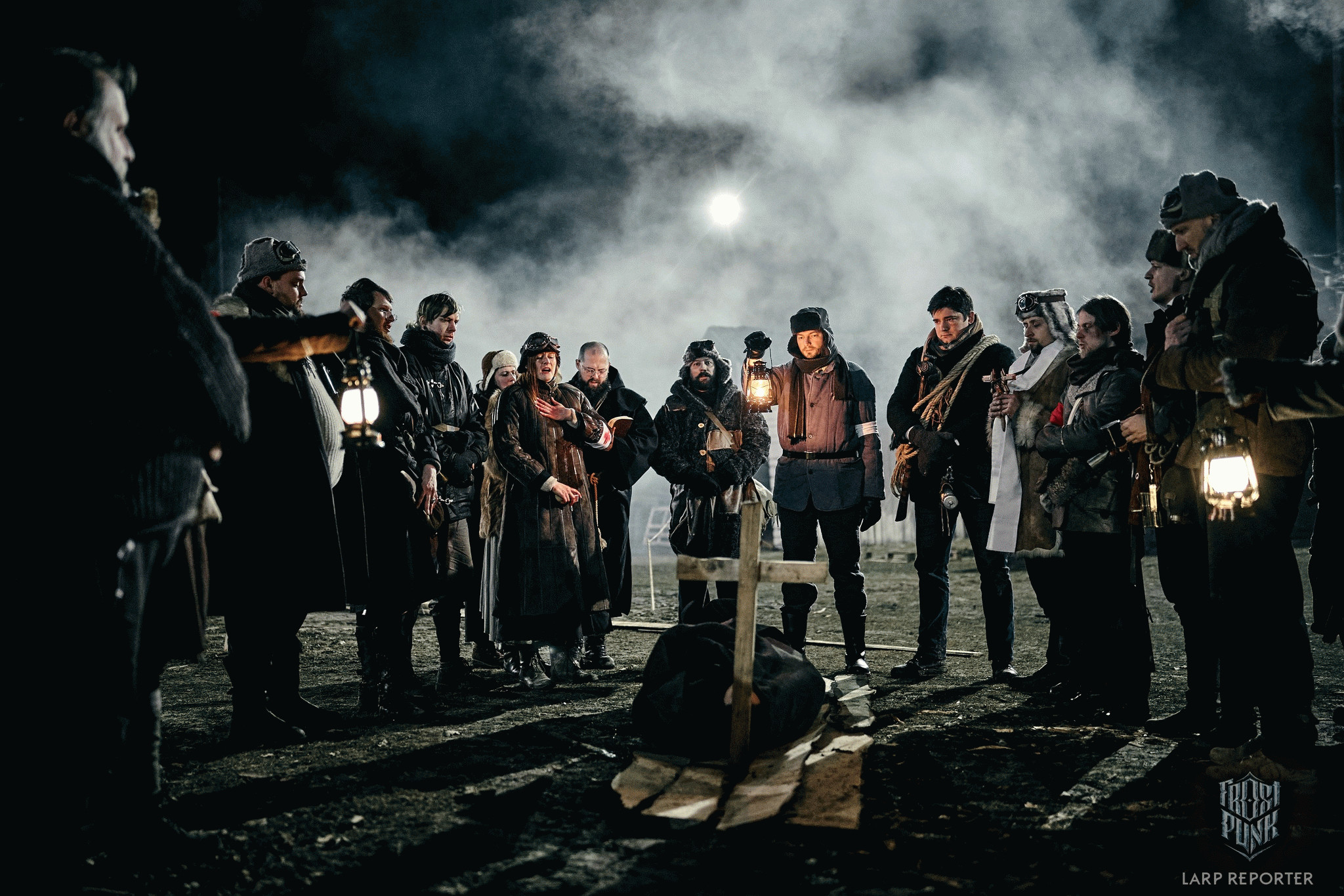 Группа людей в костюмах в стиле Frostpunk стоит вокруг импровизированной могилы.