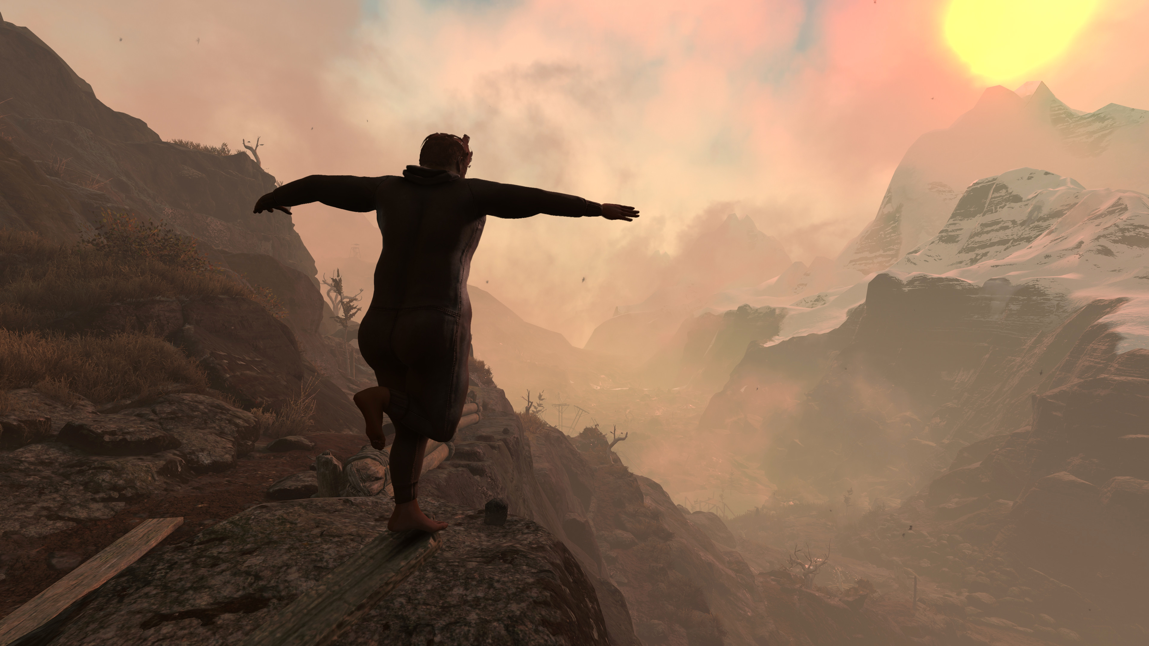 Мужчина идет у края обрыва, вдали видна гора