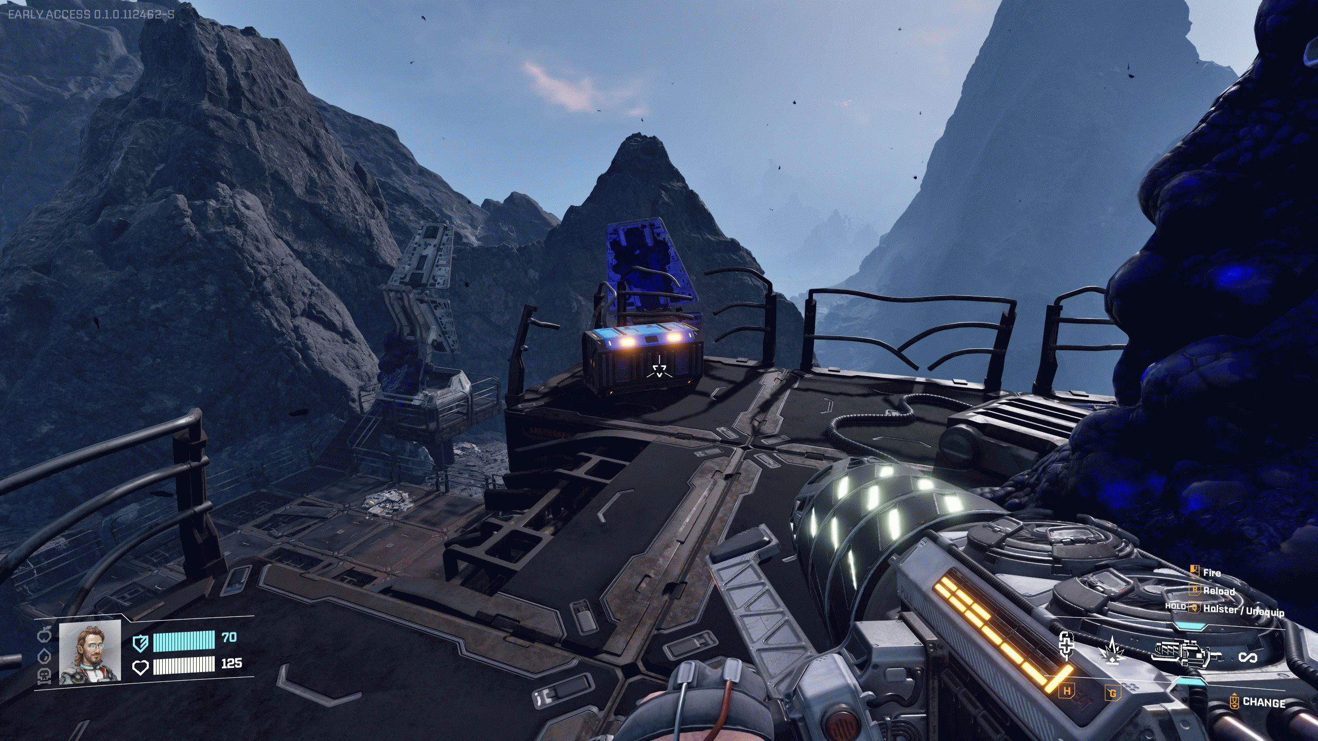 StarRupture, чертёж Стабилизатора: игрок смотрит на синий сундук на краю металлической башни с видом на горный форпост.